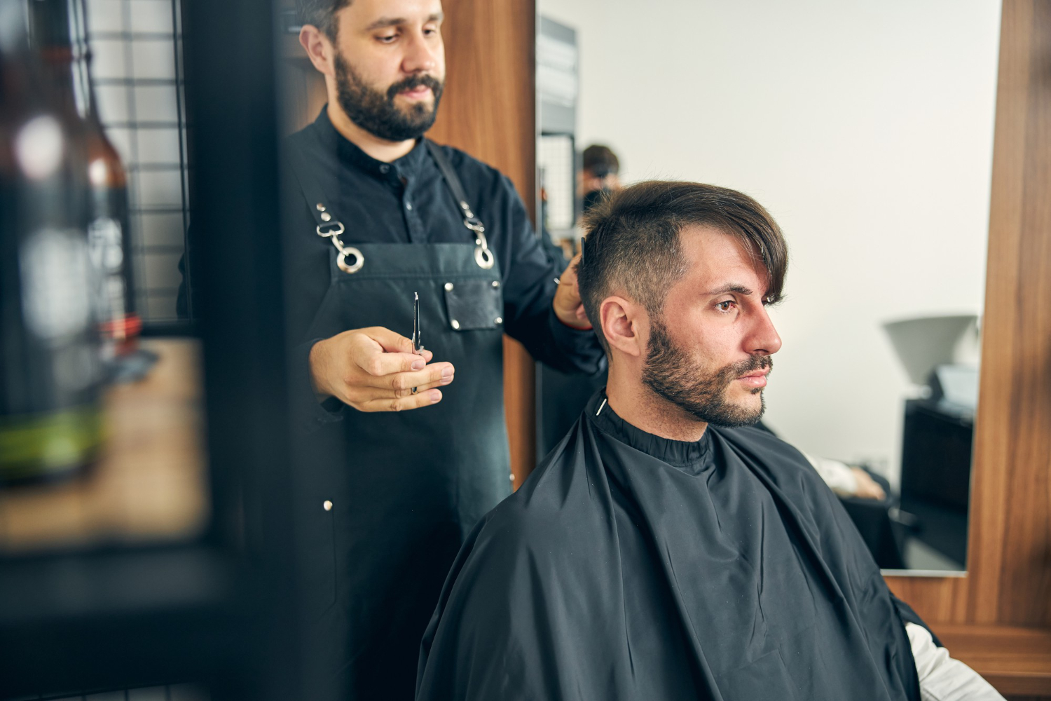 Handsome man being deep in his thoughts while sitting in front of the mirror