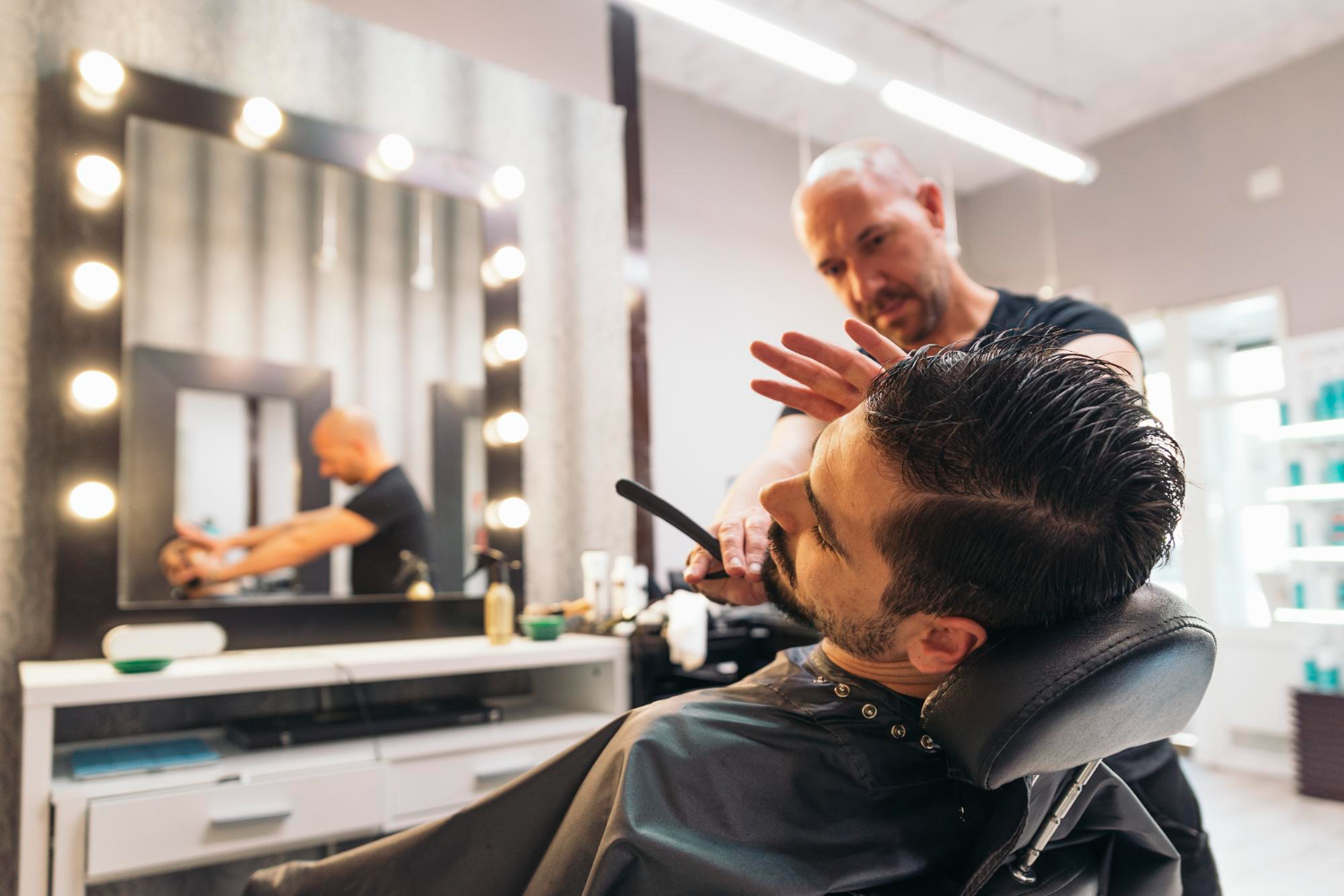 Barber shaving beard in salon